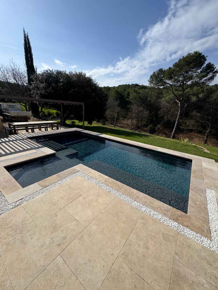 Piscine terminée entourée d'une terrasse en pierre naturelle