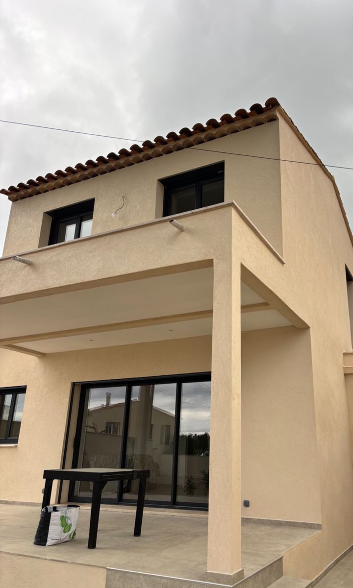 Villa avec façade enduite, toiture en tuiles et terrasse couverte