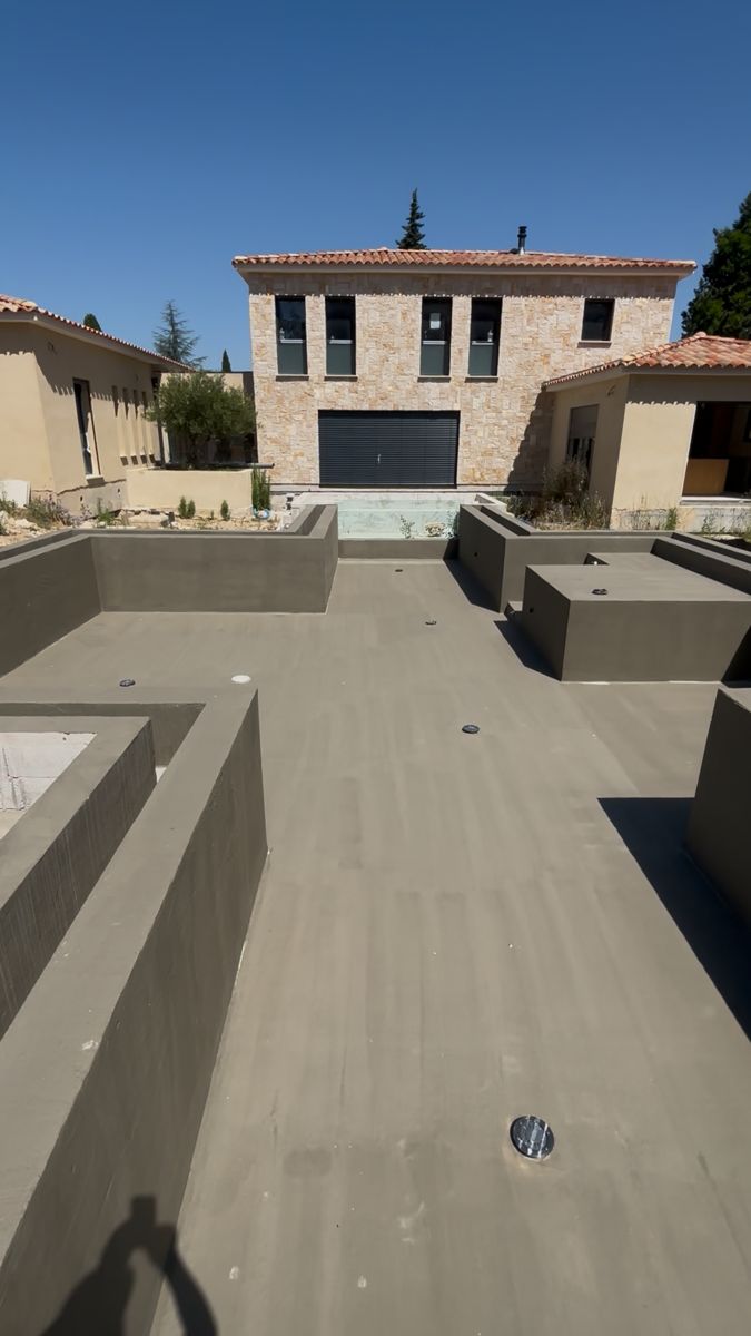 Piscine en construction devant la même maison, presque terminée, façade en pierre